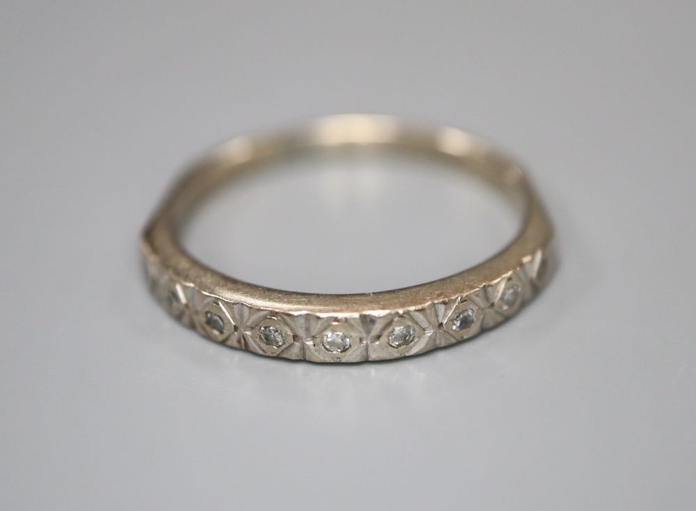 An 18ct white gold and nine stone diamond chip set half hoop eternity ring, size O, gross 2.6 grams.